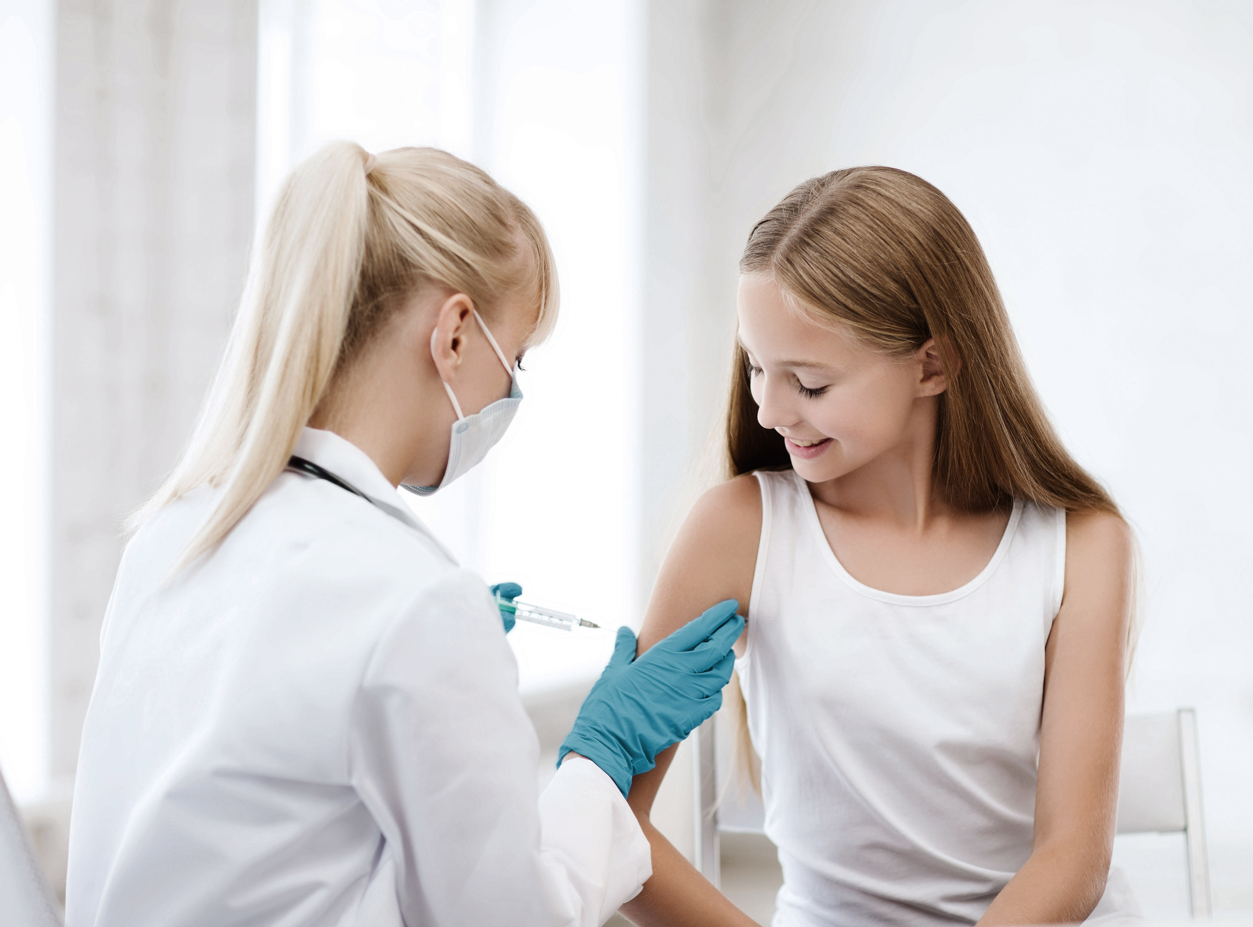 Ärztin bei der Impfung eines Mädchens